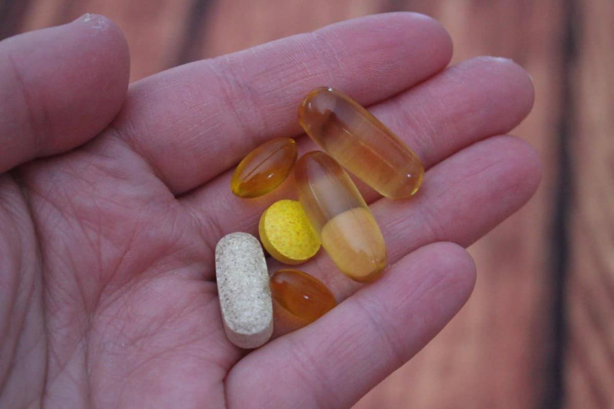 A hand holding different pills and tablets