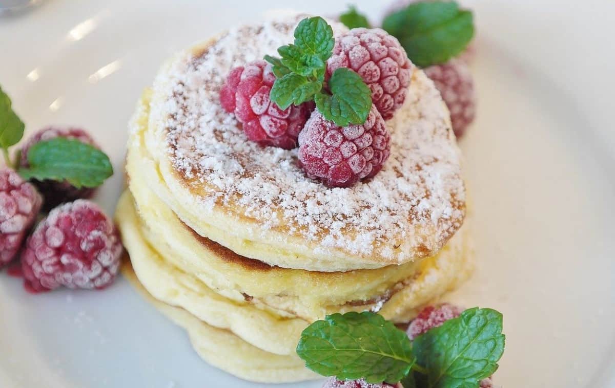 Pancake with dusted sugar and raspberry on top.