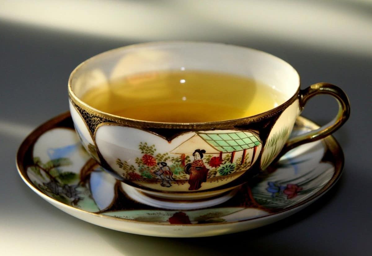 A cup of lemon-colored tea in a china cup.