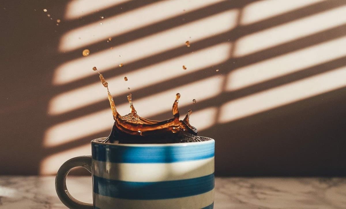 Black coffee in a white and blue striped mug.