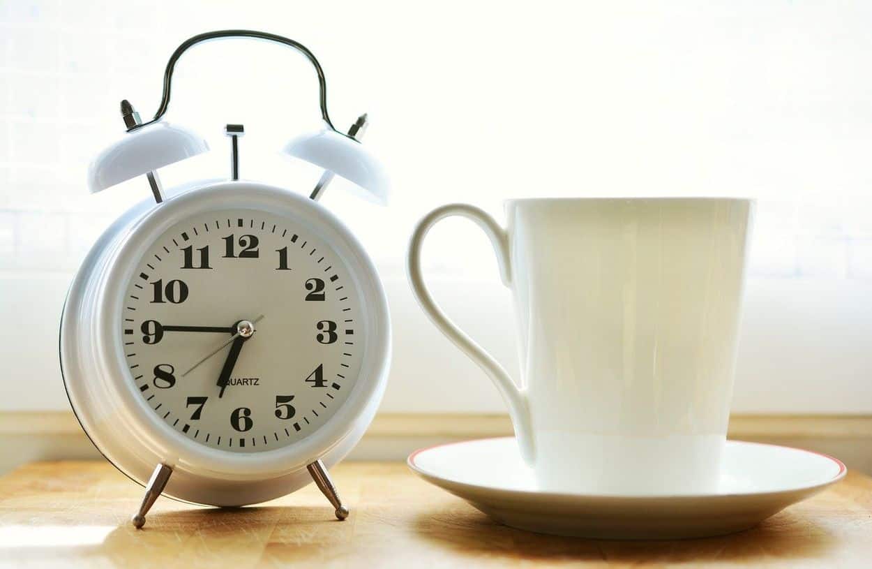 Alarm clock and a cup of coffee.
