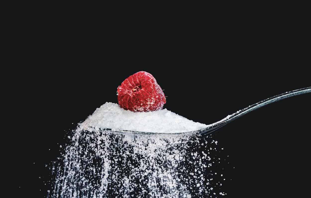 a strawberry and sugar in spoon